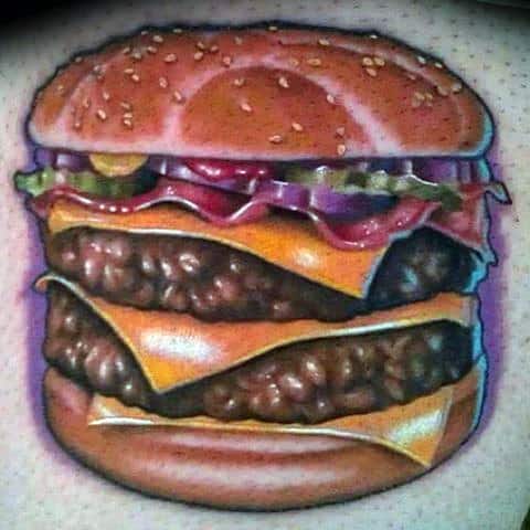 Cheeseburger tattoo featuring a double stack with lettuce, pickles, and onions on a realistic bun