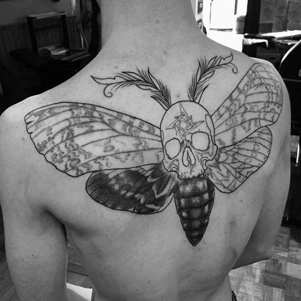 Back tattoo of a moth with a skull head, featuring the Metallica ninja star on the forehead and feather-like antennae.