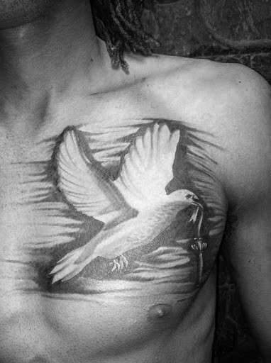 Black and white chest tattoo of a dove holding an olive branch