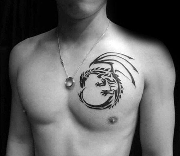 Bare-chested with dragon tattoo on left upper chest wearing a pendant necklace