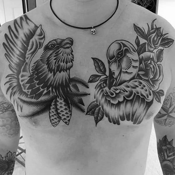 Black and grey chest tattoo featuring a hawk on the left and a swan on the right, both surrounded by detailed roses and bold linework.