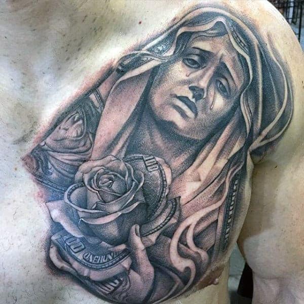 Detailed chest tattoo of a sorrowful religious figure holding a rose, intricately shaded with a money theme woven into the design