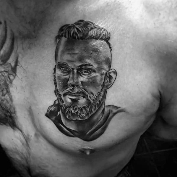 A detailed tattoo of a bearded man's face on a person's chest
