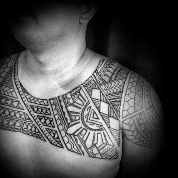 Filipino tribal tattoo spanning the chest and shoulder with bold symmetrical blocks, intricate geometric linework, and strong cultural patterning.
