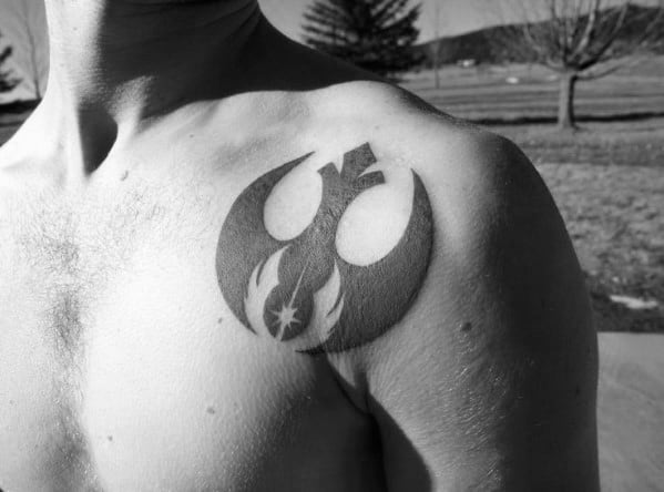Black Rebel Alliance tattoo with a flame design on the upper left chest, near the shoulder.