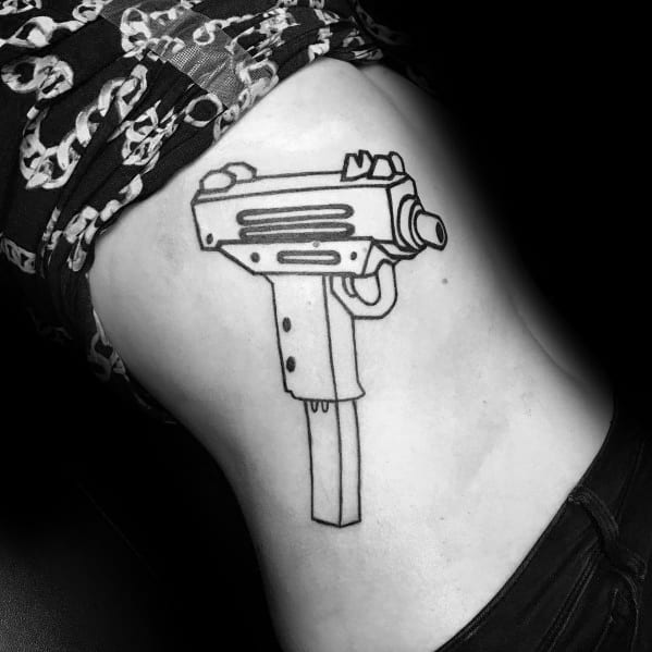 Minimalist black outline Uzi tattoo on the ribcage with clean lines and a long magazine, creating a bold yet simple firearm design.