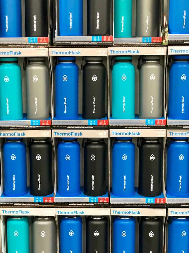 large shelf holding blue and black Thermoflask vacuum sealed bottles with company logo