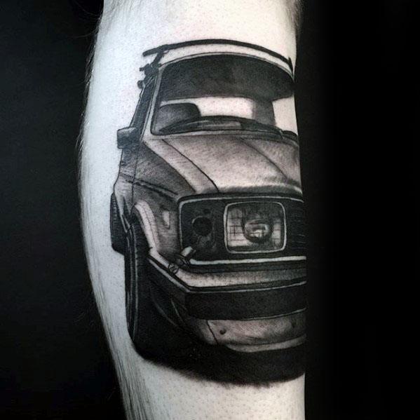 Realistic black and gray tattoo of a classic Volkswagen car front view, detailed with deep shading and bold contrast on the calf.