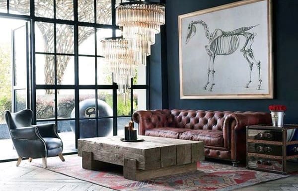 Vintage living room with leather Chesterfield sofa, wooden coffee table, and skeleton artwork.