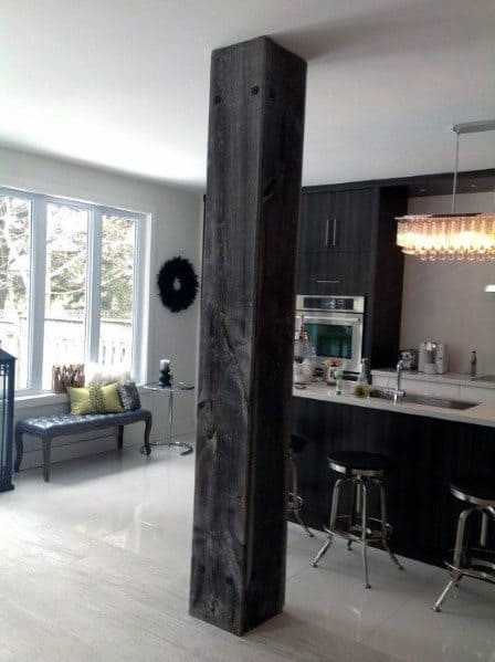 Kitchen area with vintage barn wood pole and modern barstools.
