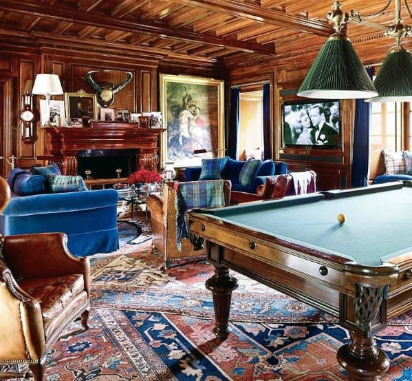 Vintage billiards room with wood paneling, classic pool table, vibrant rugs, and cozy seating area.