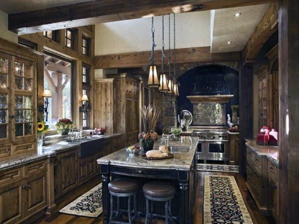 Rustic kitchen with wooden cabinets, stone countertops, pendant lights, and a dark range hood.
