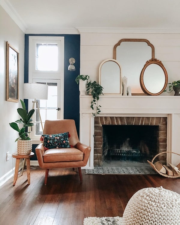 vintage tan armchair stone fireplace hardwood floors living room