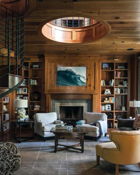Cozy library with a fireplace, comfy armchairs, and a circular ceiling above bookshelves