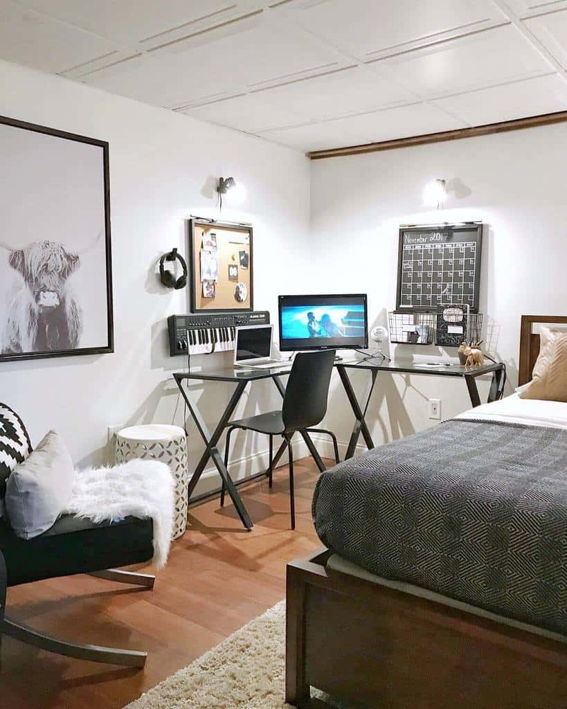Cozy bedroom with glass desk, keyboard, and modern decor in a basement office setup.