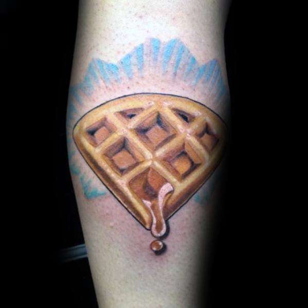 Realistic waffle tattoo shaped like a diamond, with syrup dripping from the bottom and a blue glow, combining breakfast love with a unique jewel-inspired design.