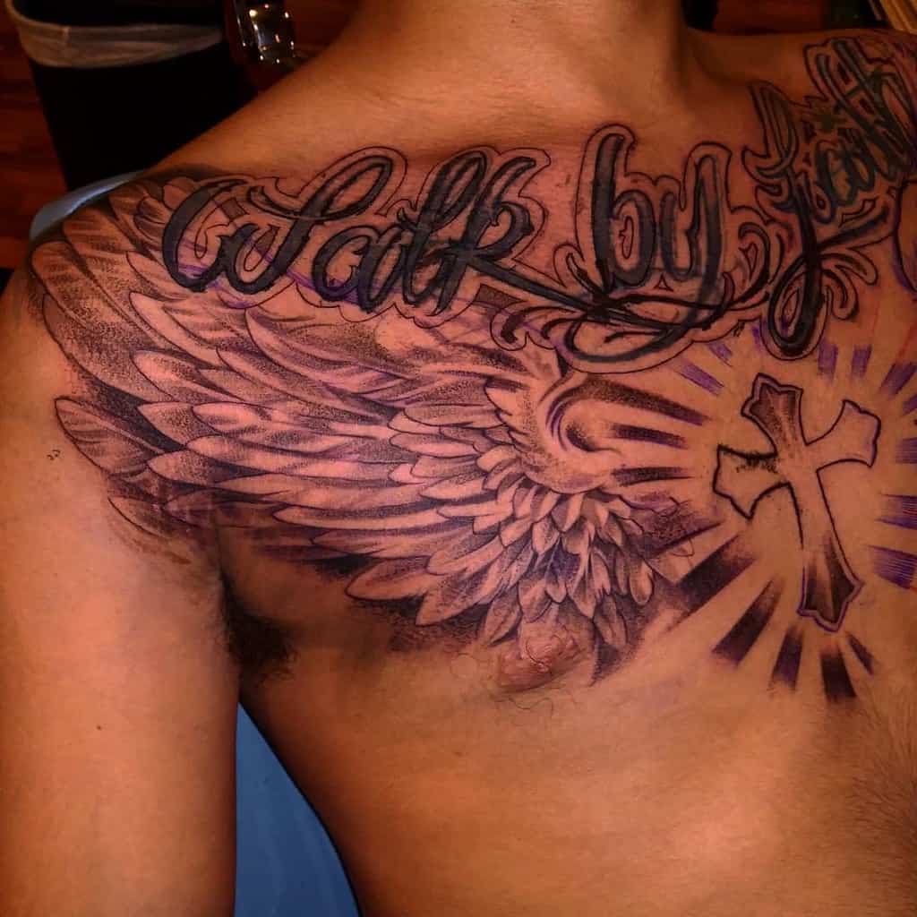 A tattoo featuring the "Walk by faith" script, angel wings, and a cross design, all in black ink
