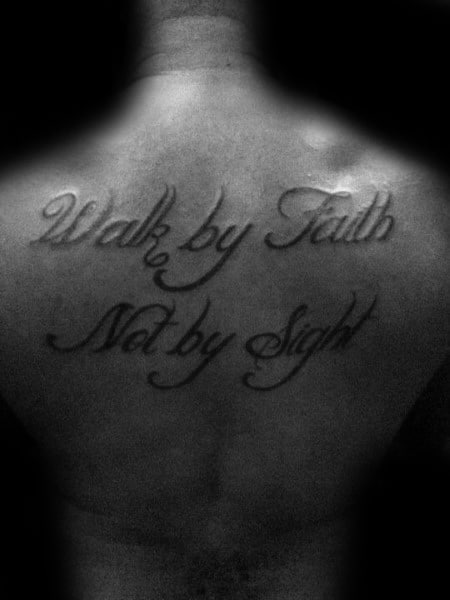 Back tattoo featuring "Walk by Faith, Not by Sight" in elegant cursive script, symbolizing faith and spiritual strength in a bold design.