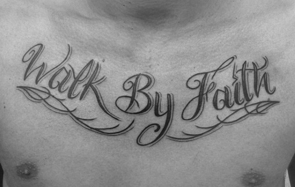 Chest tattoo featuring "Walk By Faith" in bold cursive script with decorative flourishes, creating a striking and inspirational design.