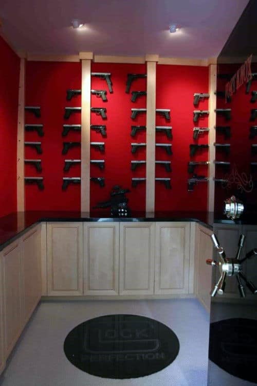 Compact Glock-themed gun room with bold red walls and sleek storage cabinets.