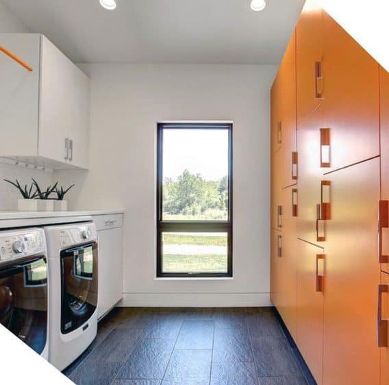 Modern laundry room with bright orange cabinets, white appliances, and a window with outdoor views.