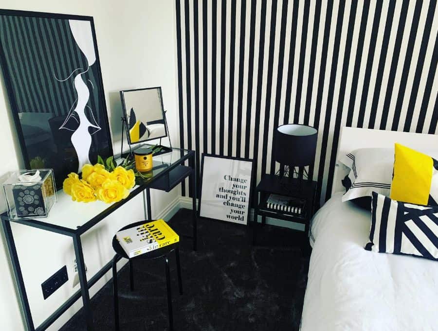 Black and white striped bedroom with yellow accents and modern decor.