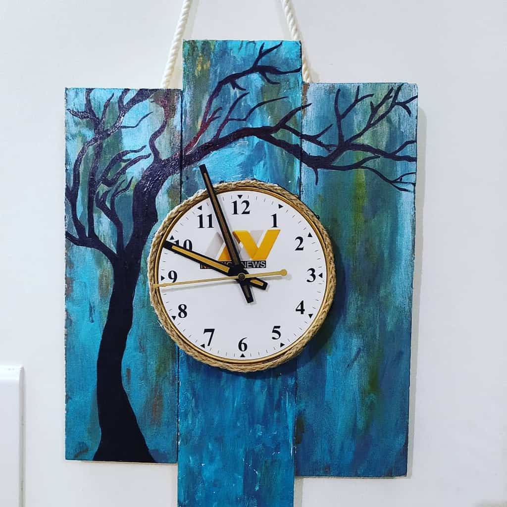 clock on blue wood planks with tree artwork