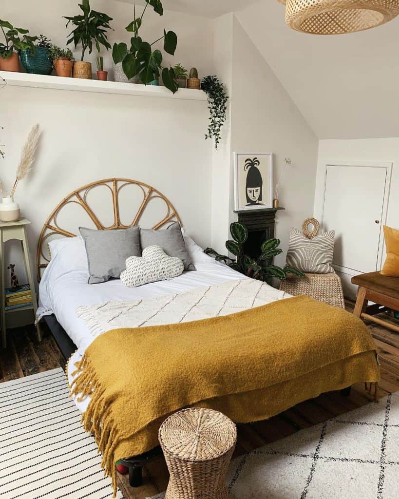 Boho bedroom with rattan headboard, plant shelf, mustard throw, and cozy natural decor.