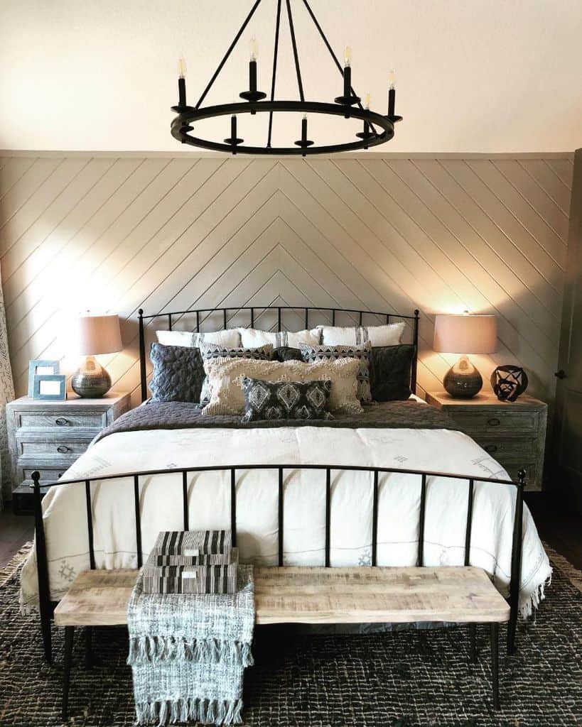 Cozy bedroom with a metal bed frame, wood accents, geometric lamps, and a black chandelier