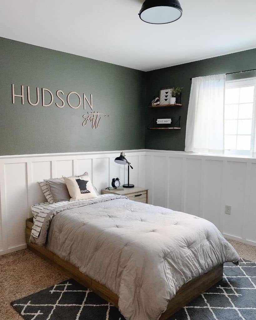 Minimalist bedroom with a green accent wall, single bed, and decorative shelves, sunlight filters through a window