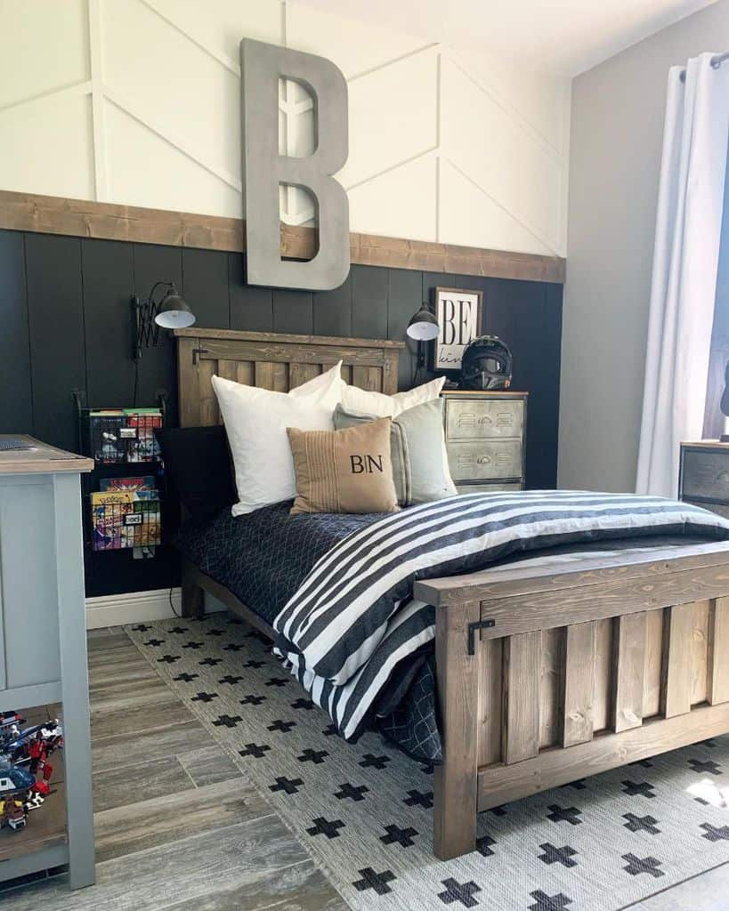 Cozy bedroom with wooden bed, striped bedding, large "B" on wall, and a patterned rug