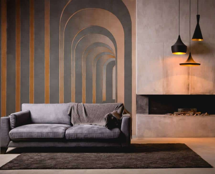Modern living room with a gray sofa, geometric wall design, rug, fireplace, and pendant lights