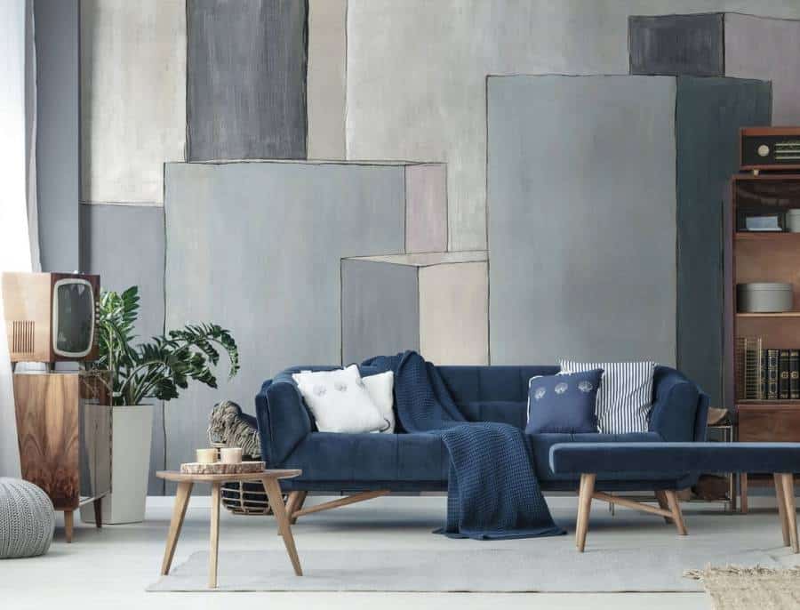 Modern living room with blue sofa, abstract wall art, vintage TV, and wooden furniture