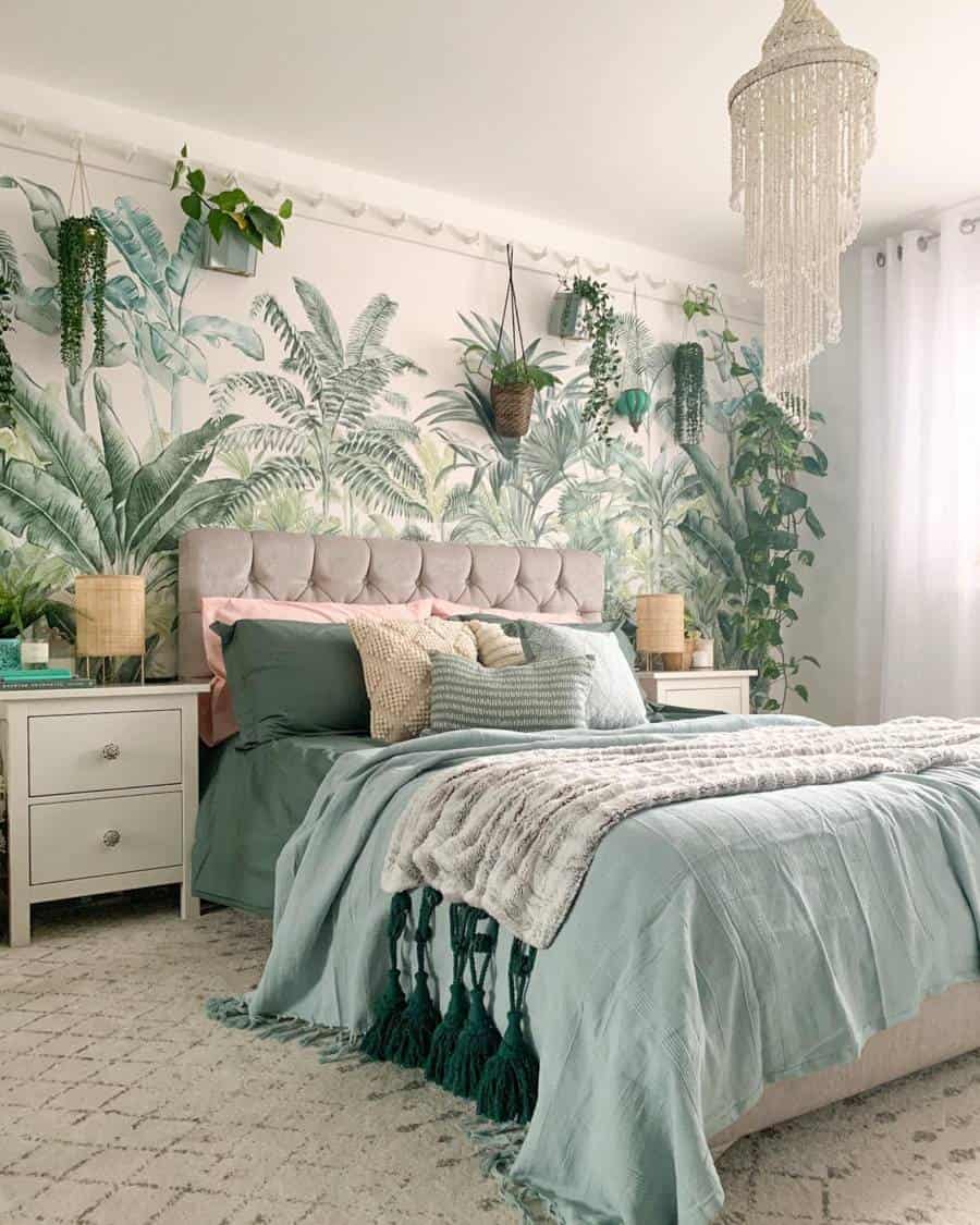 Cozy bedroom with tropical wallpaper, pastel bedding, plants, and a chandelier