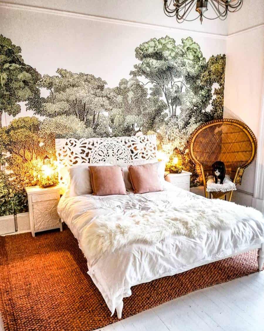 Bedroom with white ornate bed, botanical wallpaper, wicker chair, and warm lighting from lamps on nightstands