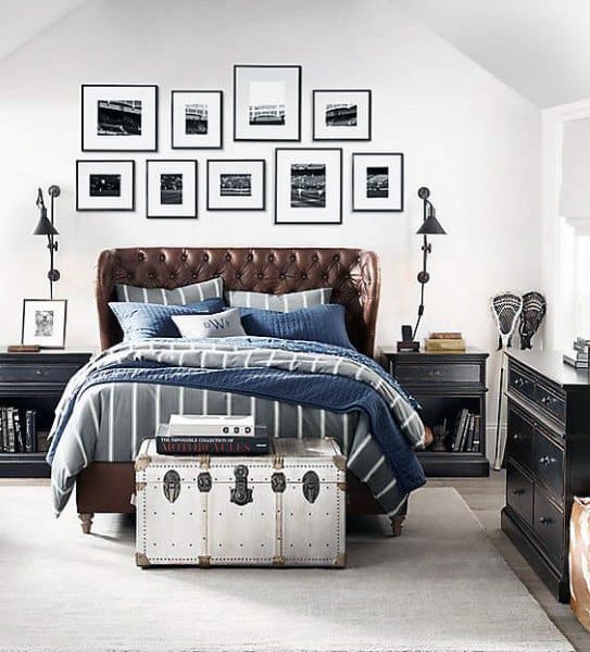 Cozy bedroom with a tufted bed, blue bedding, wall art, and a trunk at the foot of the bed