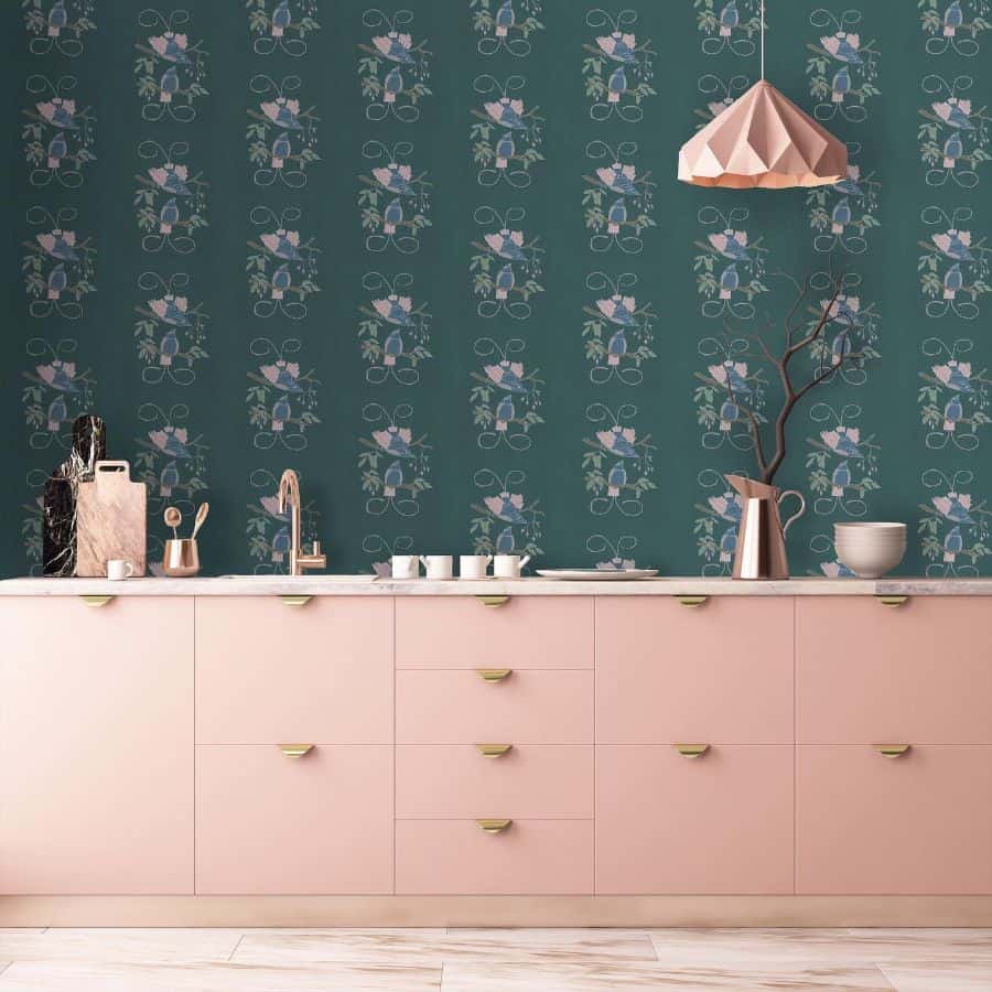 pink kitchen cabinets with gold handles and green bird wallpaper