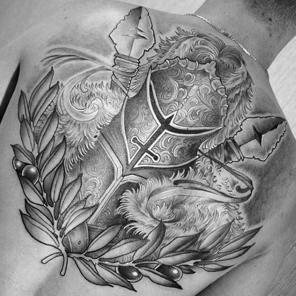 Detailed black and grey back tattoo of a Roman helmet with laurels and fur, symbolizing honor, victory, and warrior heritage.