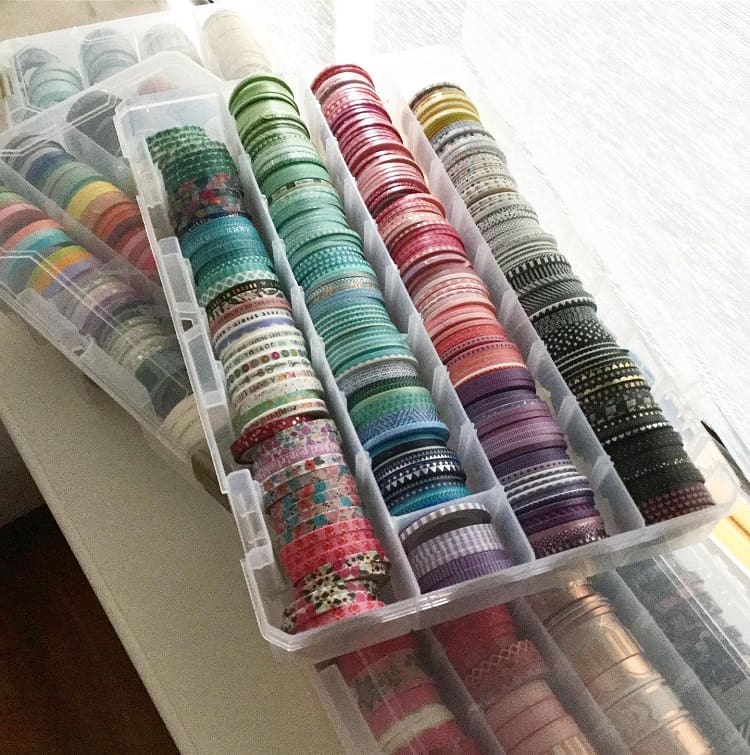 Plastic boxes filled with colorful rolls of washi tape arranged in neat rows