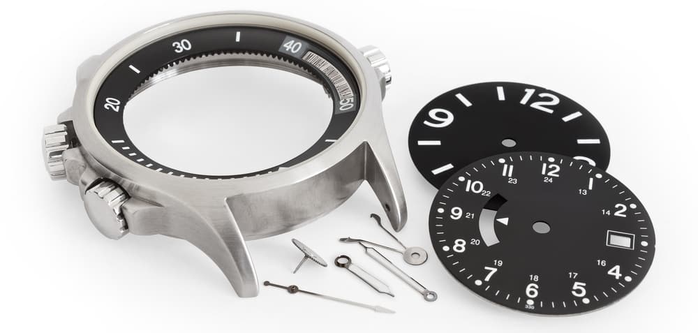 different watch parts laying on white background