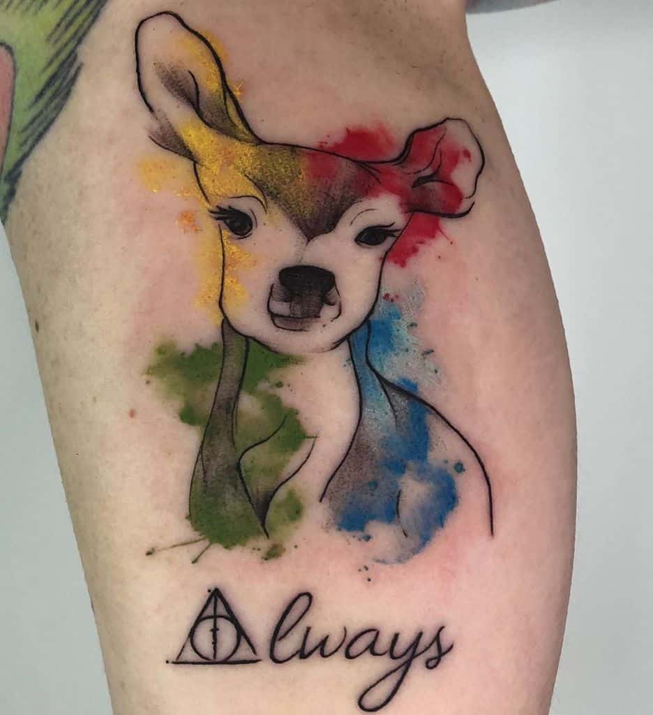 Watercolor-style tattoo featuring a doe Patronus with splashes of red, blue, green, and yellow, along with the Deathly Hallows symbol and 'Always' text.