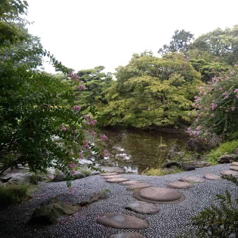 large pond in backyard with stone pathway 