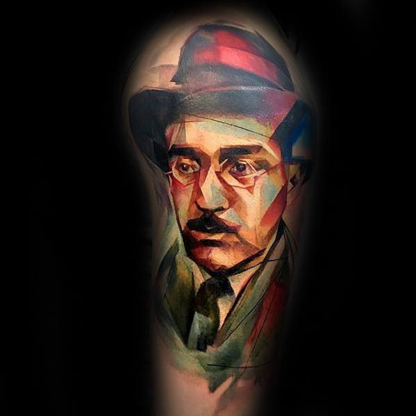 Colorful geometric tattoo of a man with a hat and glasses on a dark background
