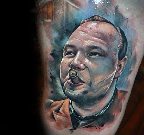 Al Capone tattoo featuring a colorful portrait of the gangster with a cigar, wearing a suit, and surrounded by vibrant details that capture his iconic look and persona.