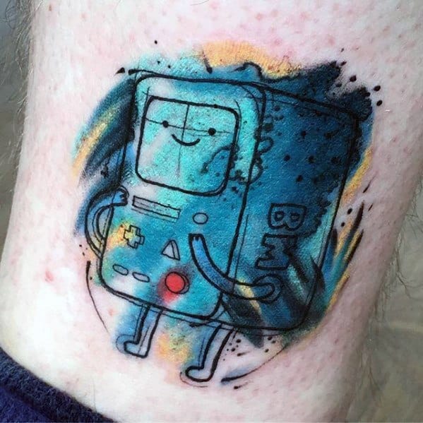 Adventure Time tattoo of BMO with a sketchy outline and watercolor-style blue, yellow, and black splashes, placed on the leg.