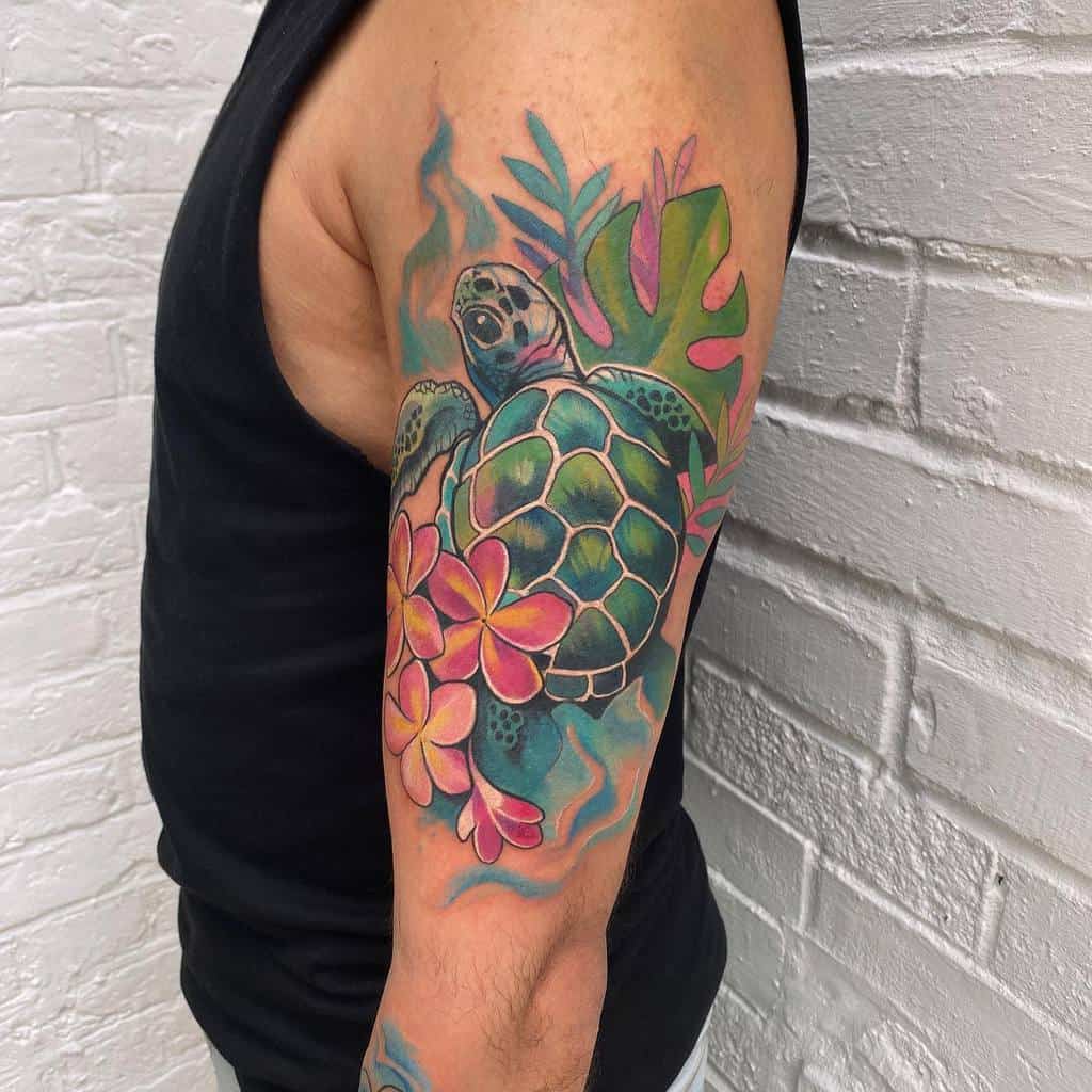 Colorful sea turtle tattoo with plumeria flowers and leaves on a man's upper arm