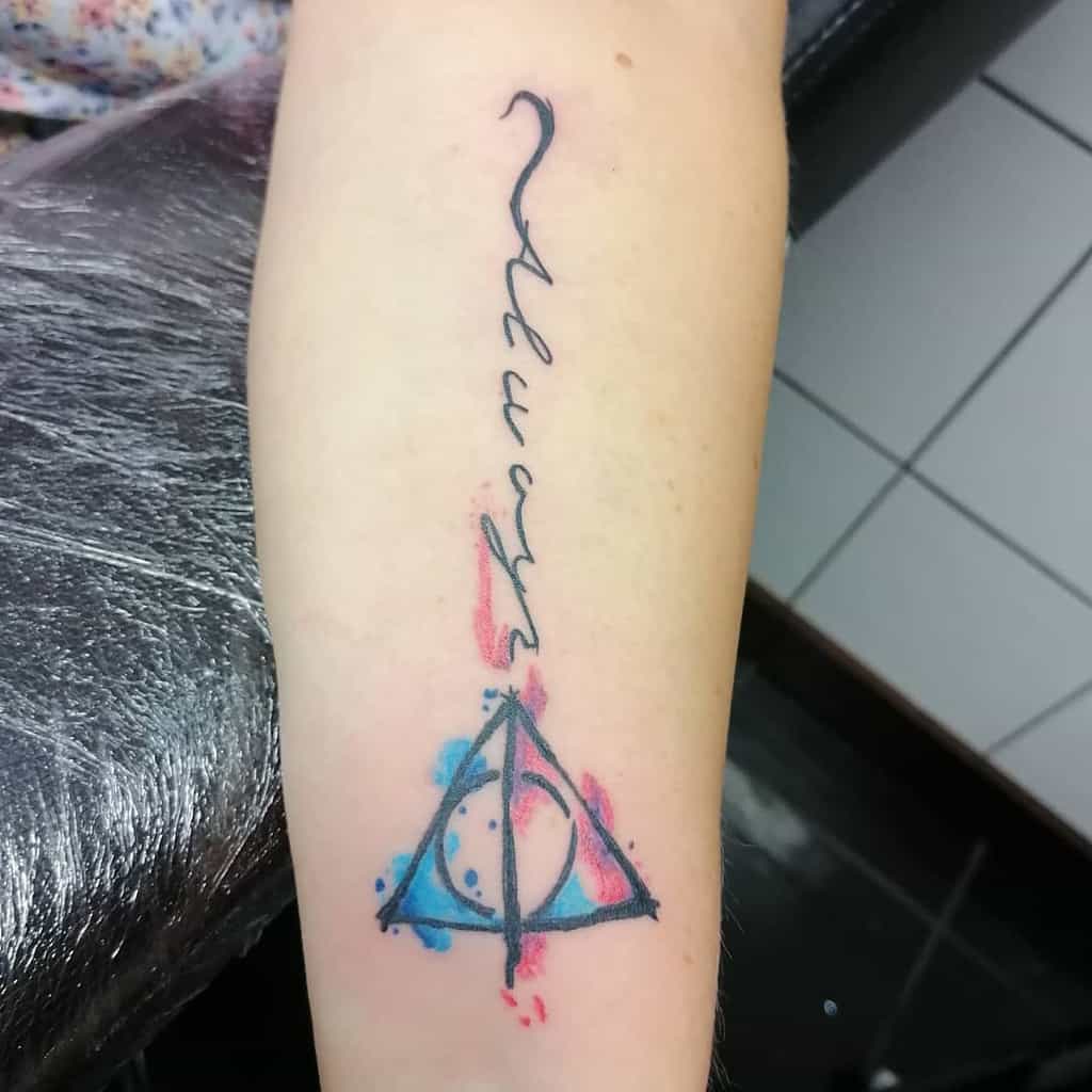 Vertical tattoo with 'Always' in cursive, watercolor accents, and the Deathly Hallows symbol featuring a moon inside