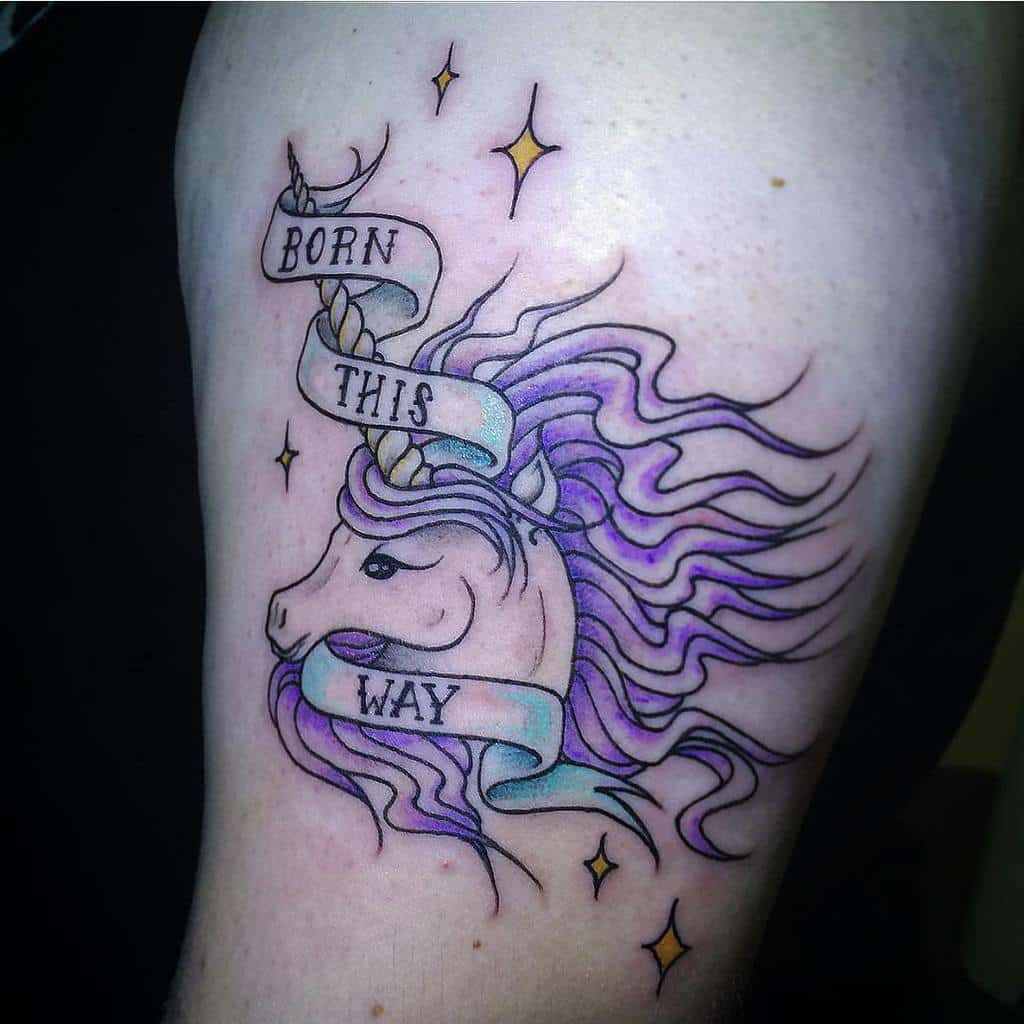 Unicorn tattoo with flowing purple mane and "Born This Way" banner, surrounded by stars