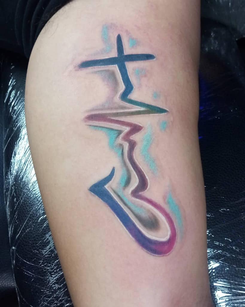 Colorful tattoo of a cross, heartbeat, and heart design on an arm