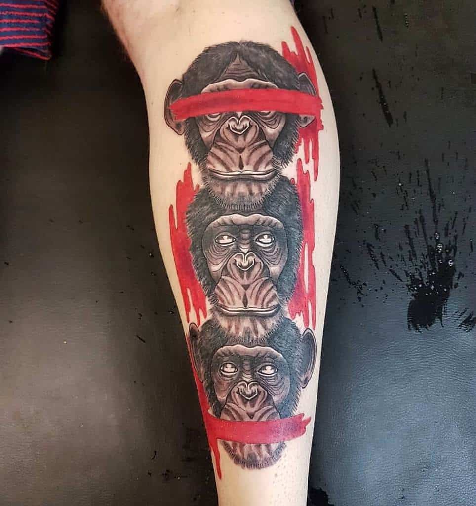 Leg tattoo of three chimpanzees stacked vertically, representing 'Hear No Evil, See No Evil, Speak No Evil,' with bold red accents and paintbrush-style strokes